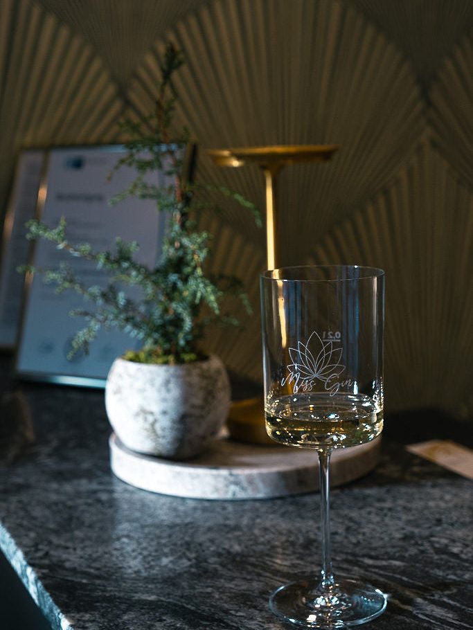 Ein Glas mit Miss-Gin-Gravur in der Lounge